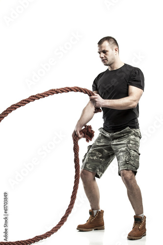 Photo: man doing rope training isolated on white - boot camp man doing rope training isolated on white - boot camp