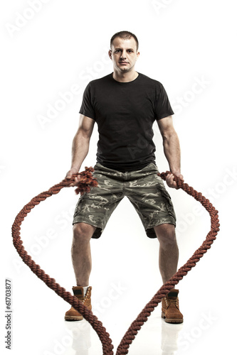 Photo: man doing rope training isolated on white - boot camp man doing rope training isolated on white - boot camp