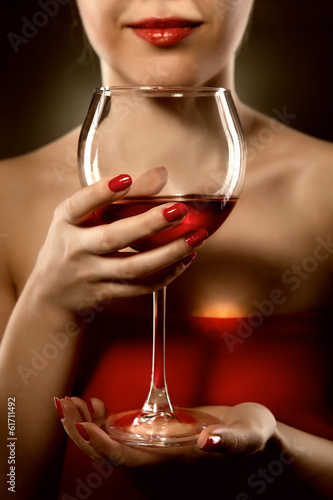 Photo: woman in red holding wine glass and smiles woman in red holding wine glass and smiles