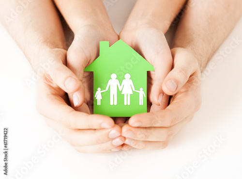 Photo: hands holding green house with family hands holding green house with family