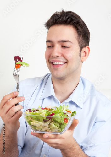 Photo: Lachender junger Mann bewundert seinen Salat Lachender junger Mann bewundert seinen Salat
