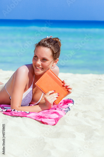 Photo: An young woman is relaxing on the beach An young woman is relaxing on the beach