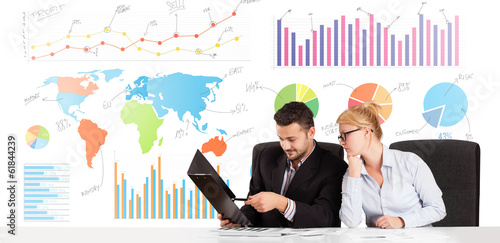 Photo: Business man and woman with colorful charts Business man and woman with colorful charts
