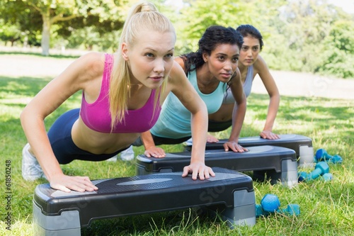 Photo: Determined women doing step aerobics Determined women doing step aerobics