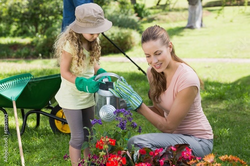 Photo: Mother with daughter watering plants Mother with daughter watering plants
