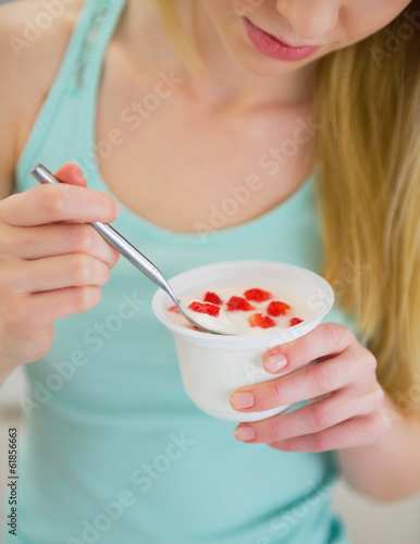 Photo: Closeup on young woman eating yogurt Closeup on young woman eating yogurt