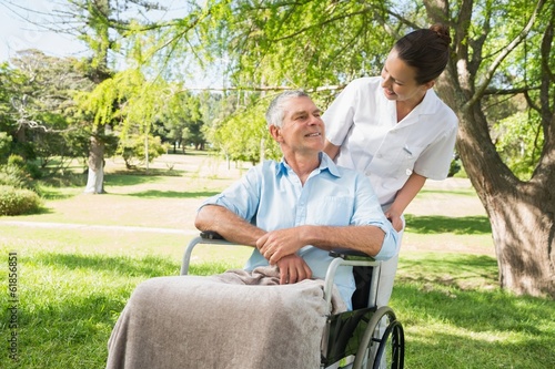Photo: Woman with her father sitting in wheel chair at park Woman with her father sitting in wheel chair at park
