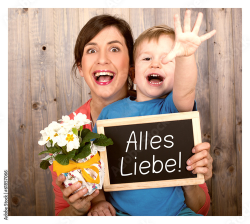 Photo: young boy celebrating mothers day with board and flowers young boy celebrating mothers day with board and flowers