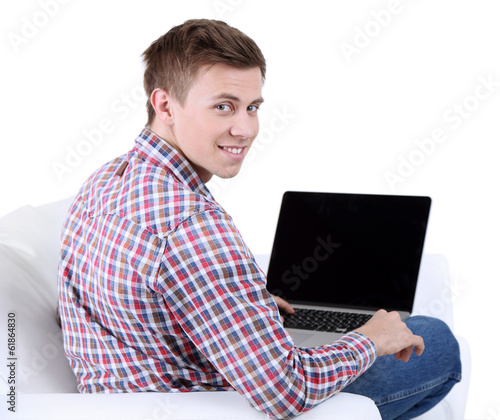 Photo: Guy sitting on sofa with laptop on white background Guy sitting on sofa with laptop on white background