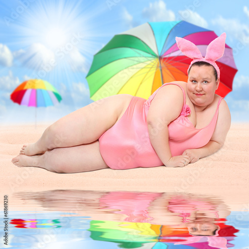 Photo: Overweight woman relaxing on a tropical beach. Overweight woman relaxing on a tropical beach.