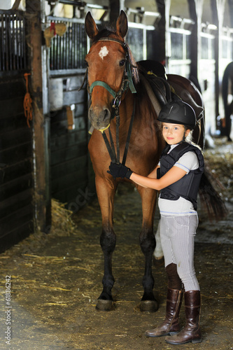 Photo: Horse and lovely equestrian girl in the stable Horse and lovely equestrian girl in the stable