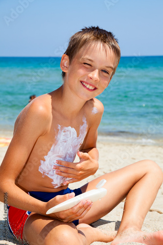 Photo: Child apply too much of sunblock cream Child apply too much of sunblock cream