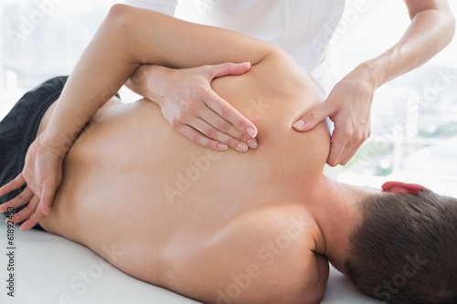 Photo: Physiotherapist massaging man Physiotherapist massaging man
