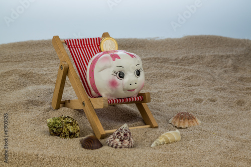 Photo: Liegestuhl mit Sparschwein und Euro Liegestuhl mit Sparschwein und Euro