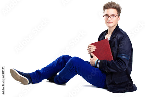 Photo: Young man sitting on floor and reading a book Young man sitting on floor and reading a book
