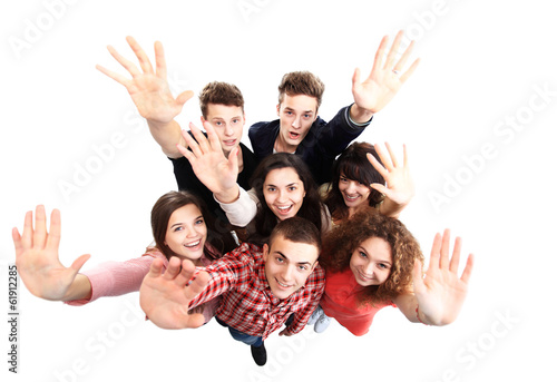 Photo: Group of happy joyful friends standing with hands up Group of happy joyful friends standing with hands up