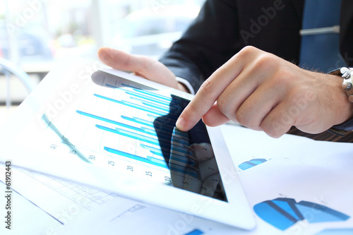 Photo: office worker using a touchpad to analyze statistical data office worker using a touchpad to analyze statistical data