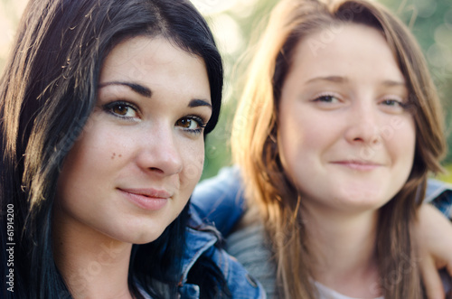 Photo: Two beautiful young friends posing arm in arm Two beautiful young friends posing arm in arm