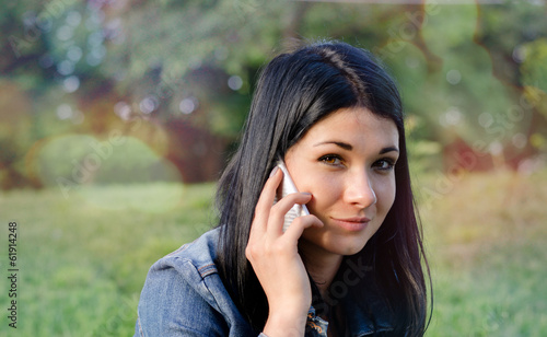 Photo: Young girl listening to a call on her mobile Young girl listening to a call on her mobile