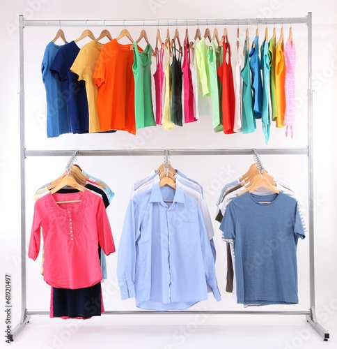 Photo: Different clothes on hangers, on gray background Different clothes on hangers, on gray background