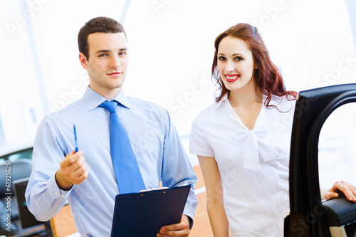 Photo: Young woman at car salon Young woman at car salon