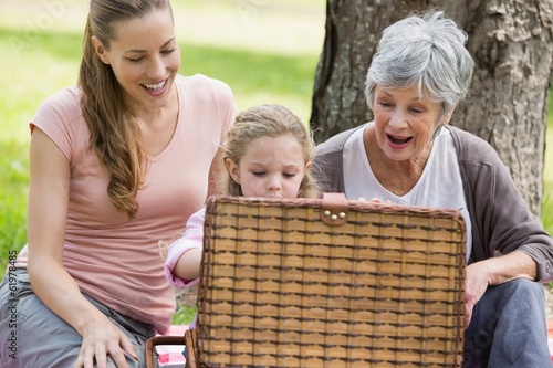 Photo: Grandmother mother and daughter with picnic basket at park Grandmother mother and daughter with picnic basket at park