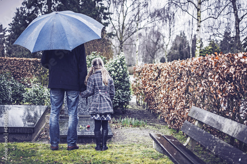 Photo: Man with little girl visiting graveyard of deceased wife Man with little girl visiting graveyard of deceased wife