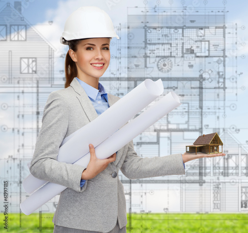 Photo: smiling architect in white helmet with blueprints smiling architect in white helmet with blueprints