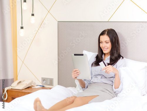 Photo: happy businesswoman with tablet pc in hotel room happy businesswoman with tablet pc in hotel room