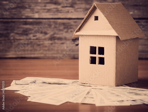 Photo: House from the paper and money on wooden background House from the paper and money on wooden background