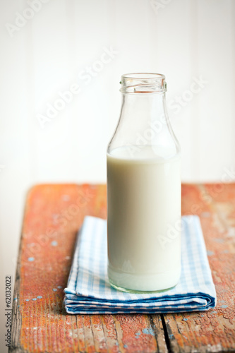 Photo: milk in bottle on old wooden table milk in bottle on old wooden table