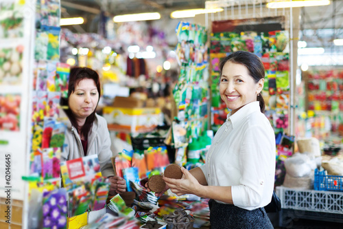 Photo: Happy mature woman chooses solid fertilizer Happy mature woman chooses solid fertilizer