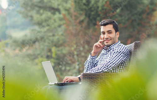 Photo: Profile of a young man with laptop, outdoor Profile of a young man with laptop, outdoor