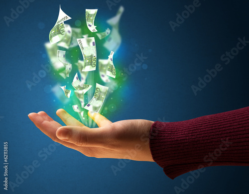 Photo: Glowing money in the hand of a woman Glowing money in the hand of a woman