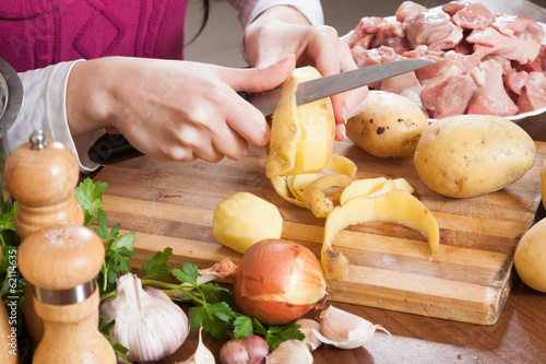 Photo: hands cleaning potatoes at table in kitchen hands cleaning potatoes at table in kitchen