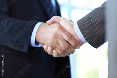 Photo: Closeup of business people shaking hands over a deal Closeup of business people shaking hands over a deal