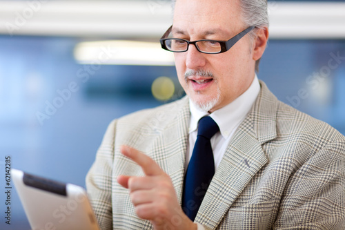 Photo: Smiling businessman using a tablet Smiling businessman using a tablet