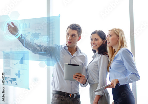 Photo: business team working with tablet pcs in office business team working with tablet pcs in office