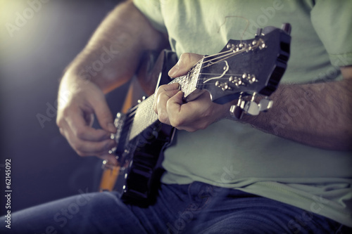 Photo: Close up on man`s hand playing guitar Close up on man`s hand playing guitar