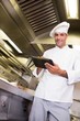 Smiling male cook using digital tablet in kitchen Smiling male cook using digital tablet in kitchen
