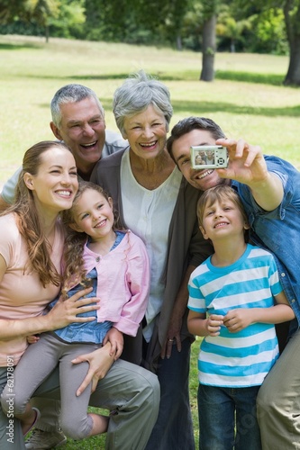 Photo: Man taking picture of extended family at park Man taking picture of extended family at park