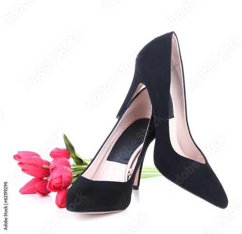 Photo: Beautiful black female shoes and flowers, isolated on white Beautiful black female shoes and flowers, isolated on white