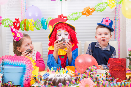 Photo: children giving gifts on birthday party with clown children giving gifts on birthday party with clown
