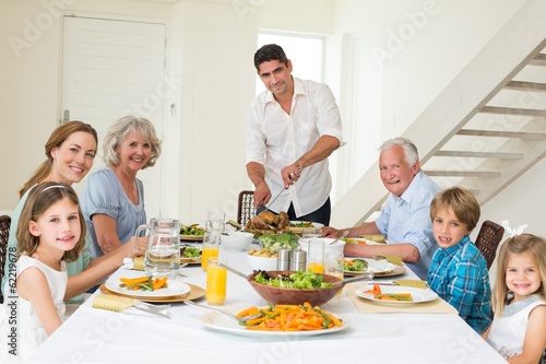 Photo: Smiling father serving meal to family Smiling father serving meal to family