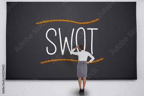 Photo: Businesswoman considering the word swot Businesswoman considering the word swot
