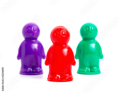 Photo: three small toy businessmans of the different colors three small toy businessmans of the different colors