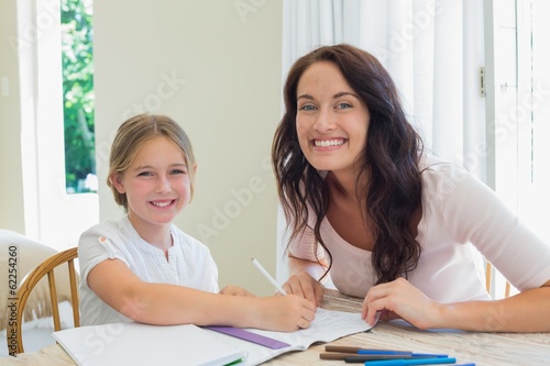 Photo: Mother and daughter drawing together at table Mother and daughter drawing together at table