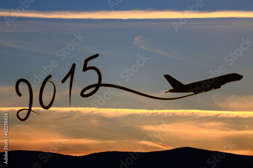 Photo: New year 2015 drawing by airplane on the air at sunset New year 2015 drawing by airplane on the air at sunset