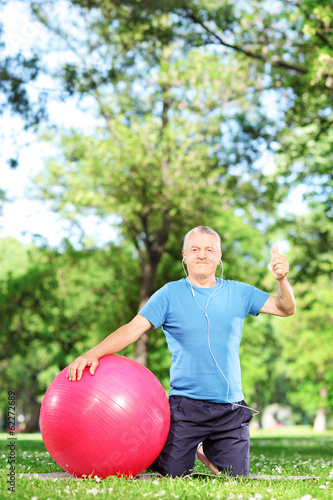 Photo: Man sitting in park with pilates ball Man sitting in park with pilates ball