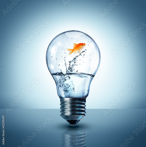 Photo: energy change concept - goldfish jumping into a light bulb - up energy change concept - goldfish jumping into a light bulb - up